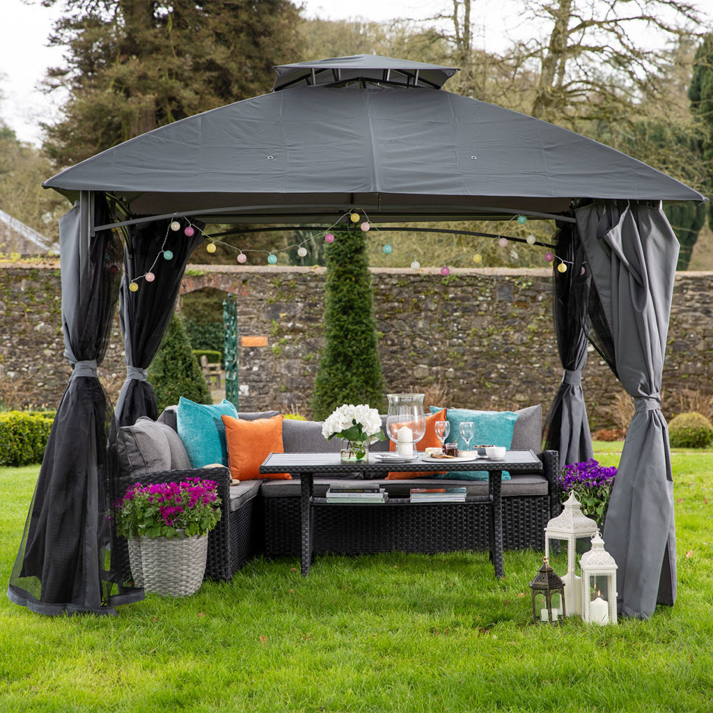 Outdoor L shape couch with table set under black gazebo in garden