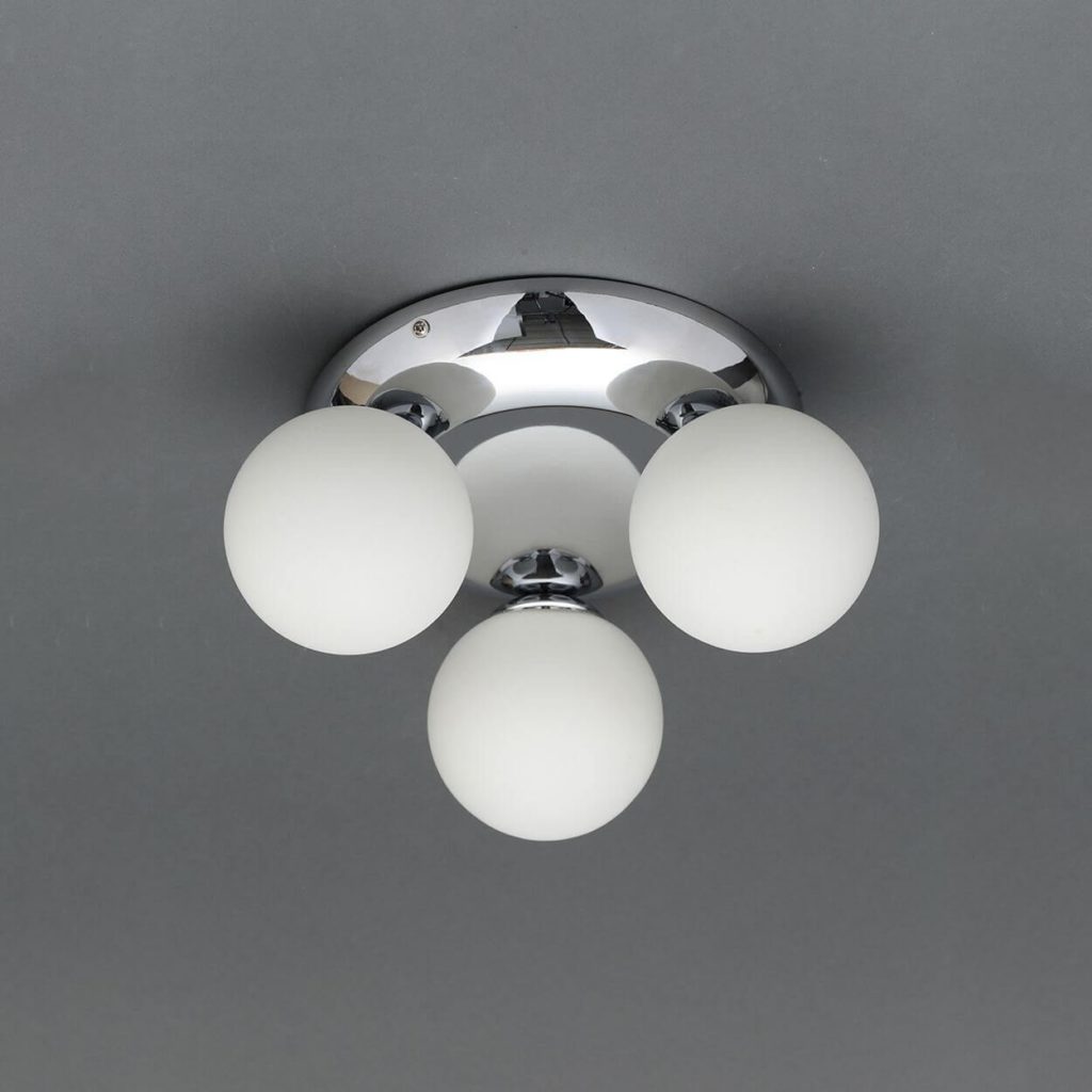 Mounted silver light fixture with three white balls on a grey ceiling