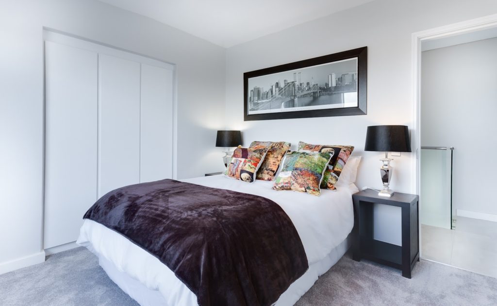 A bright bedroom with two lamps on either side of the bed 