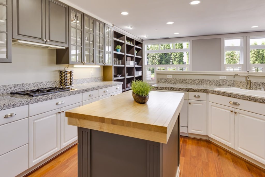 A clean white kitchen with a bar kitchen island top