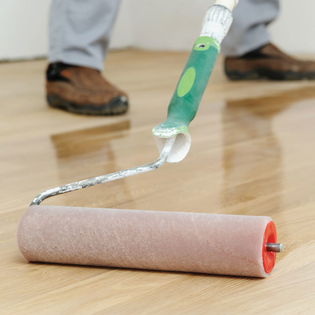 Wide roller in action being used to varnish floors effectively