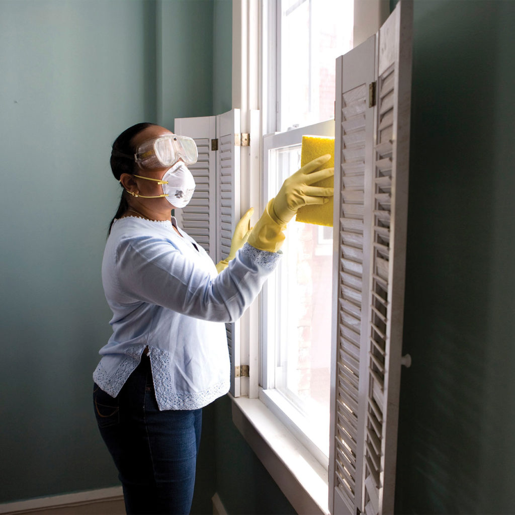 a woman wearing protective mould and damp removing gear.