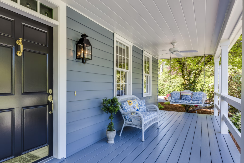 A house is painted a muted blue exterior paint colour with white trim to add balance.
