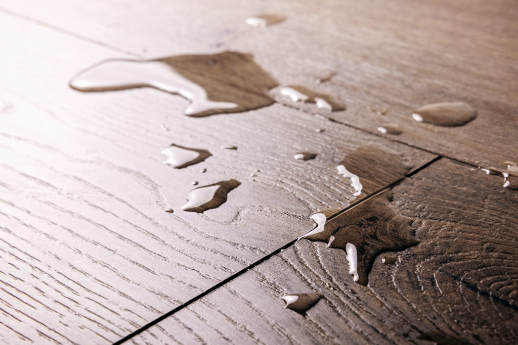 waterproof flooring - spilled water drops on wooden laminate floor