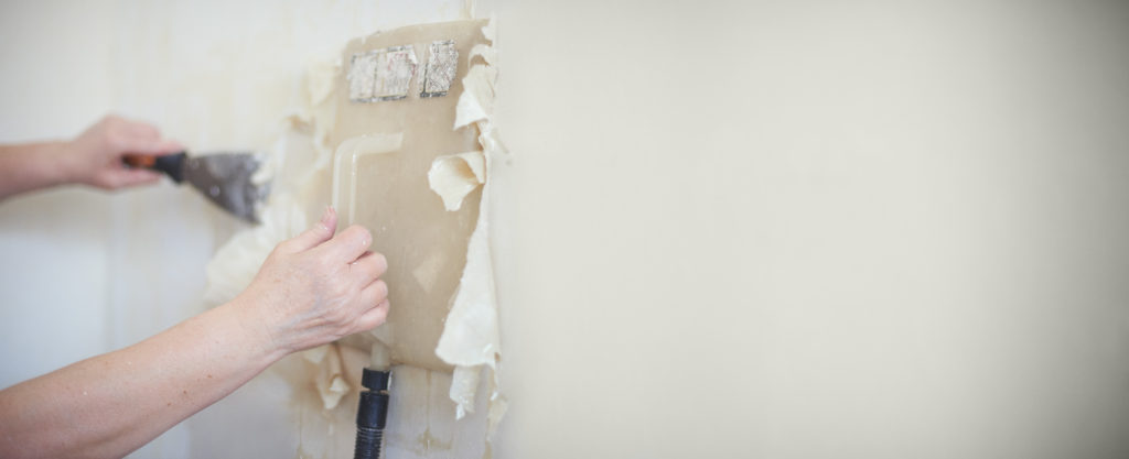 Person removing wallpaper with a steamer 