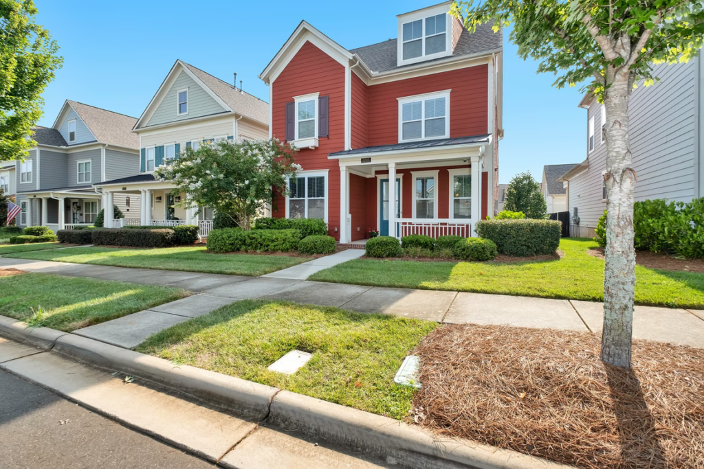 A small family home is painted with a muted red exterior paint colour.