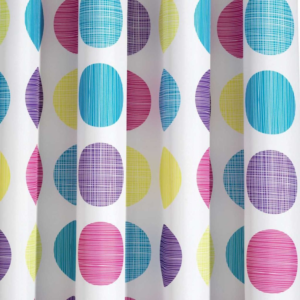 Close up of white shower curtain with multi coloured spots throughout