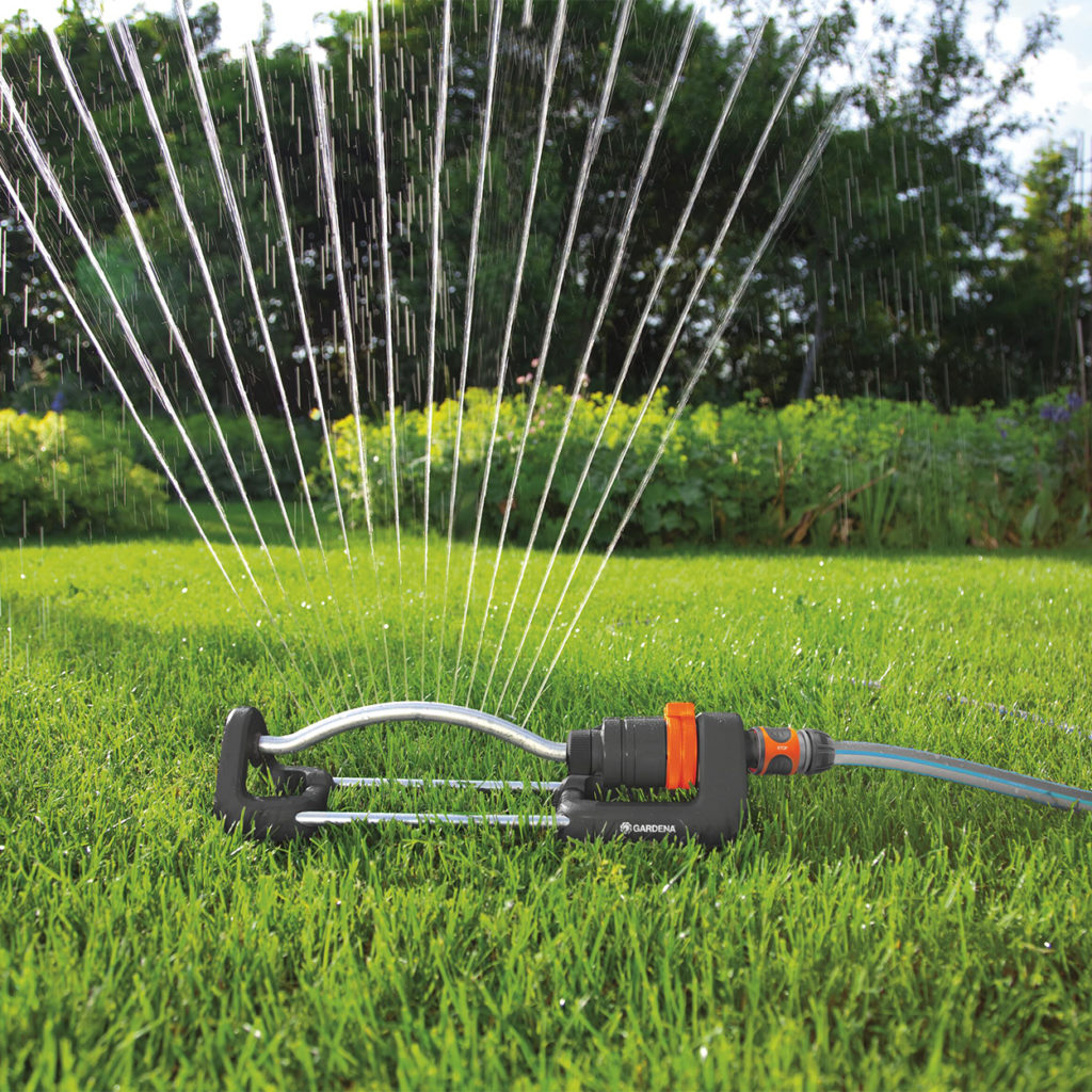 Sprinkler sprinkling water around garden