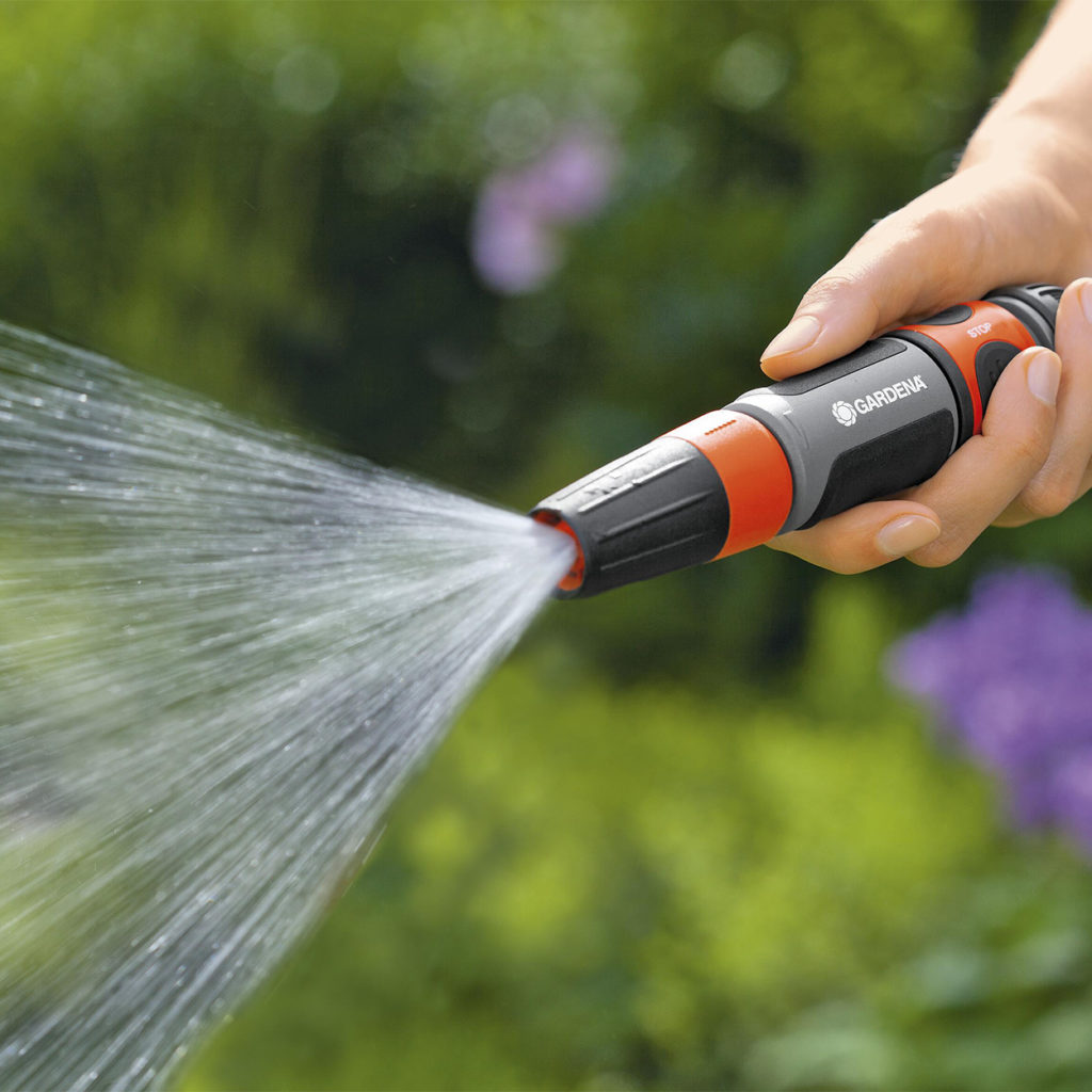 close up of hose gun spraying water