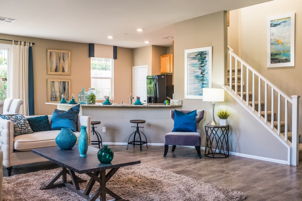 A living room and a kitchen use the same beige paint colour to make the interior space look larger.