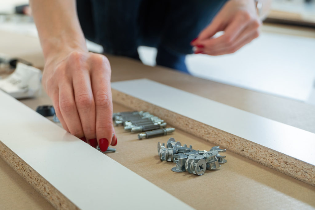 Self assembling furniture at home by a woman kneeling down