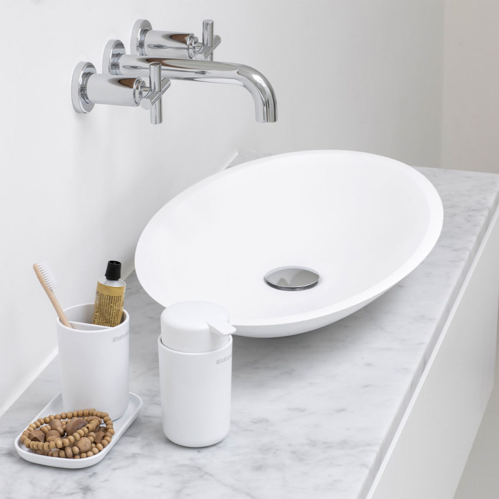 white bathroom accessories beside bathroom sink