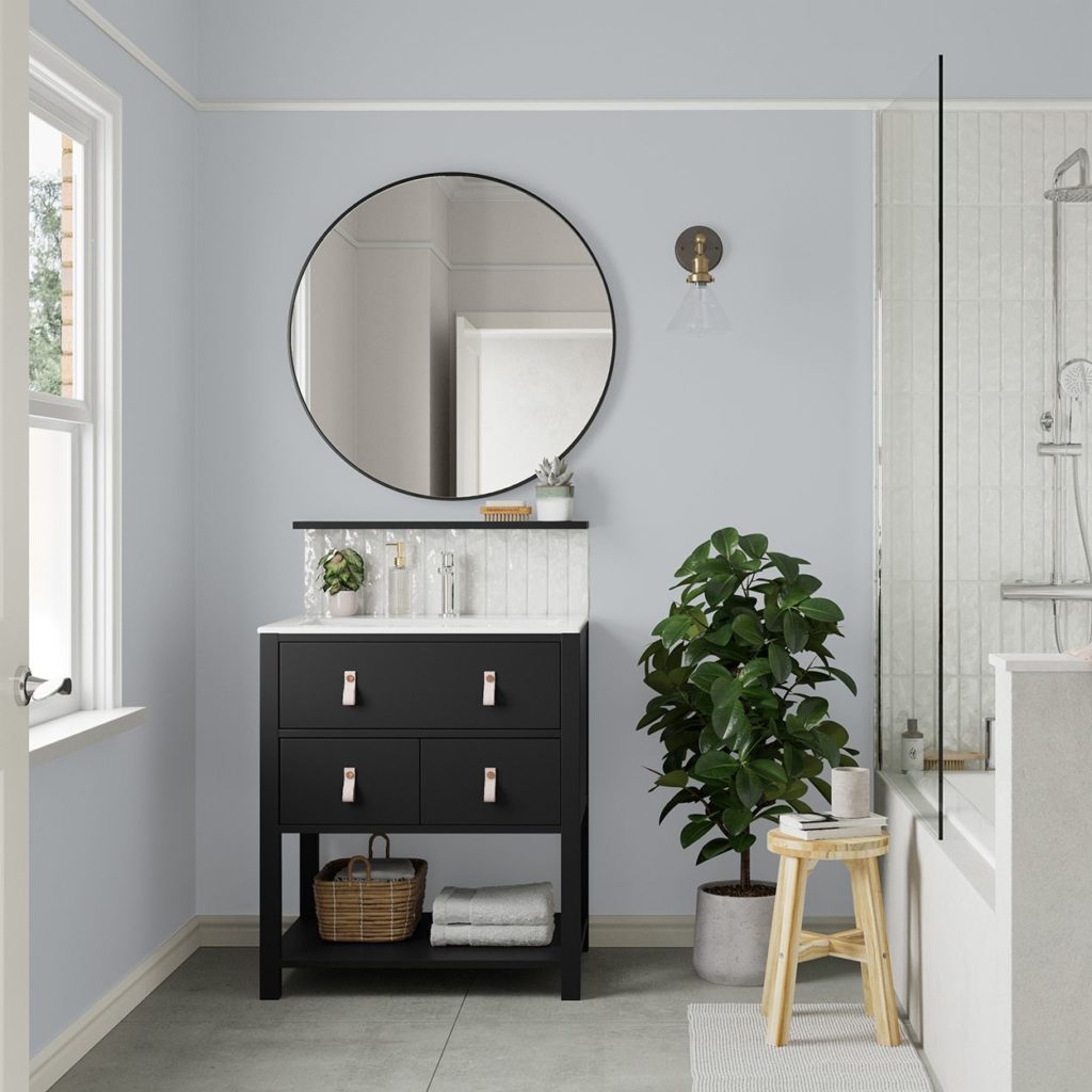 ensuite bathroom with blue wall, round mirror and black vanity unit