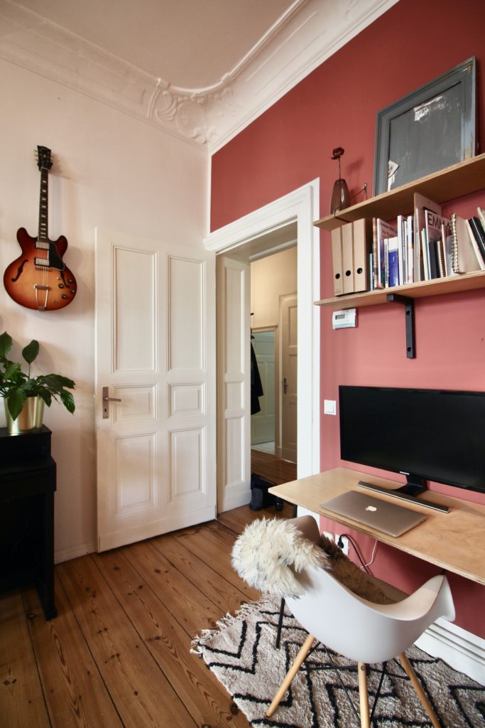  A home office workstation against a bright, coloured wallpaper accent wall.