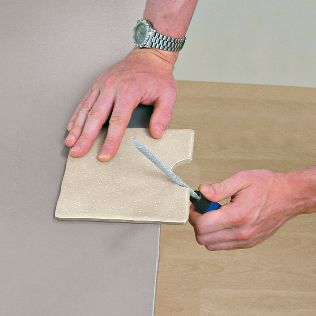 A vitrex tile file being used to smooth uneven edges