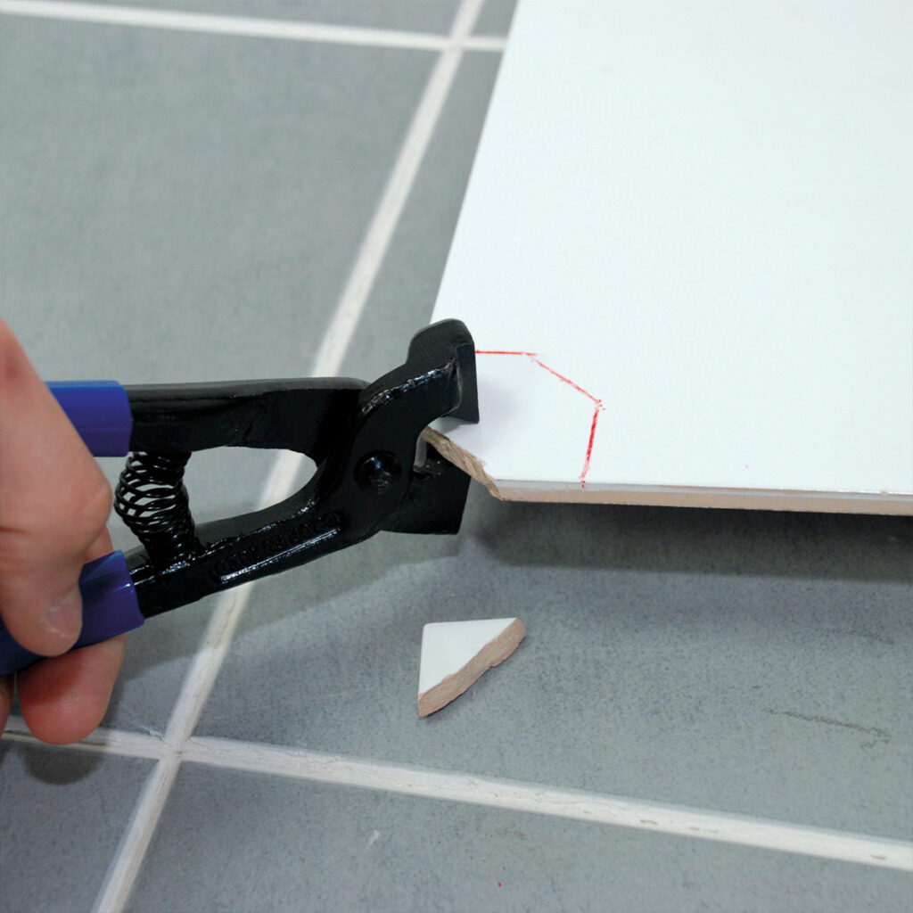 An image of tile nipper being used to make cuts in tile.