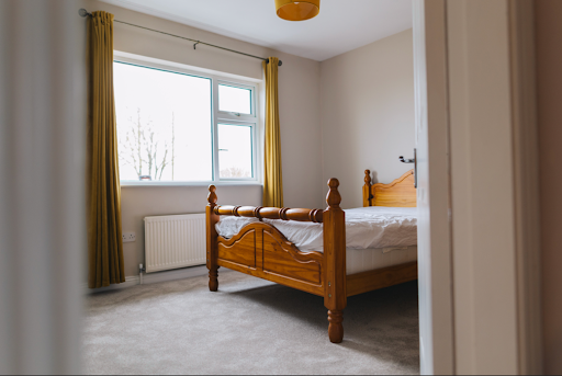 image of a bedroom with a bed beside a window